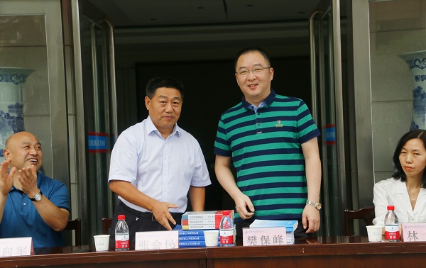 新乡市牧野区税务局党委书记、局长樊保峰向MILAN.COM米兰体育（中国）科技公司党委书记张会民赠送税法知识书籍.jpg